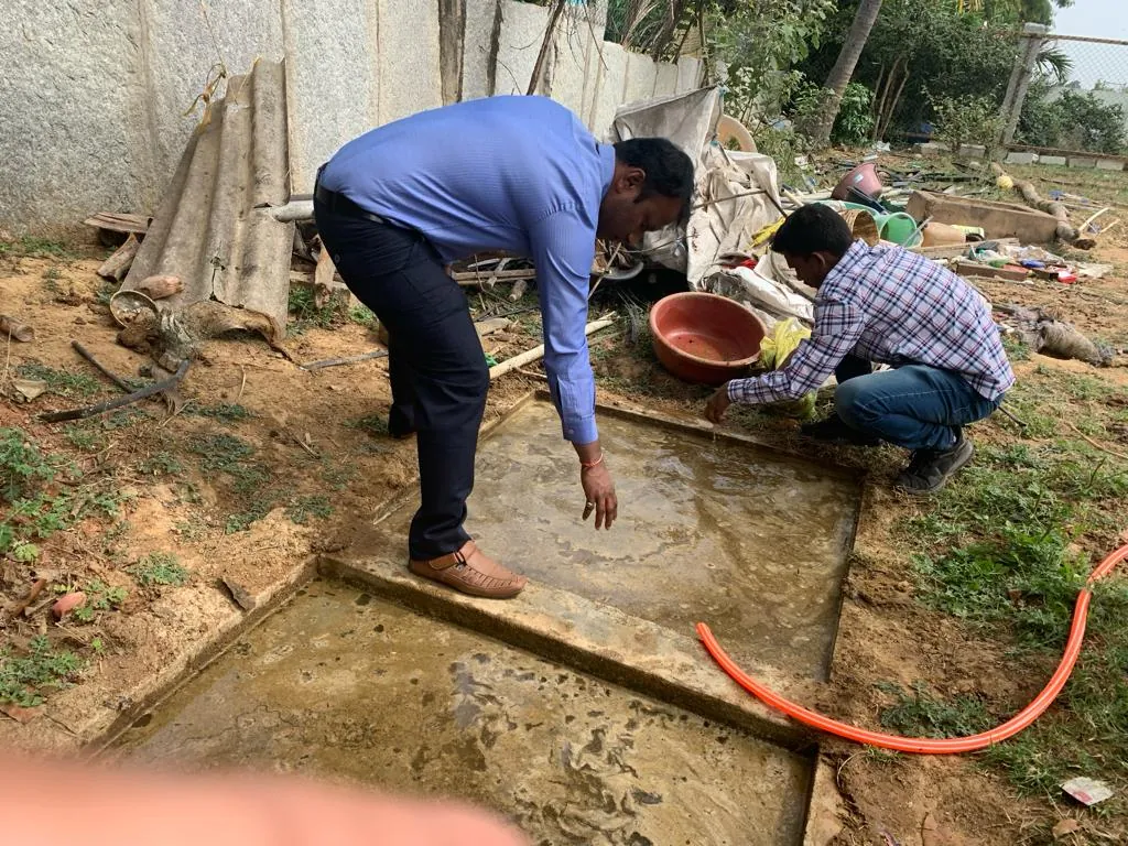 Inspecting a concrete water tank during development work at the goshala